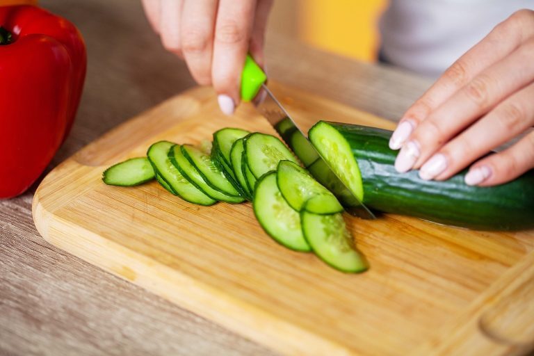A person cutting a cucumber. GREENHOUSE Goodness